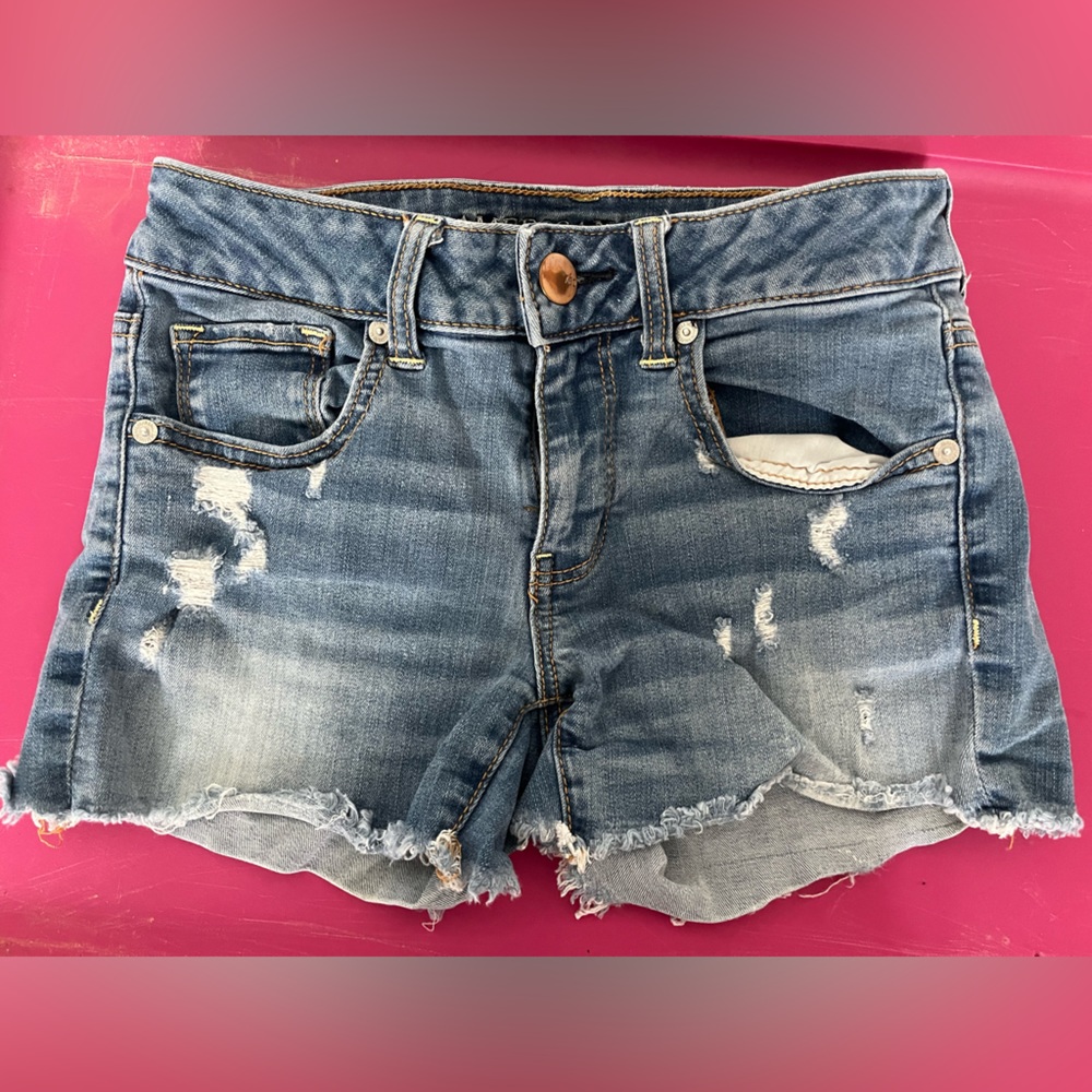 American Eagle distressed 4”denim short, more distressed on front, some on back.